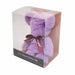 A lavender purple teddy bear shaped towel gift inside a clear plastic display box with a dark base label. The bear has a dark brown ribbon tied around its neck with 'be you' printed on it.