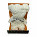 A plush, bear-shaped white towel gift with a silver ribbon tied around its neck, displayed inside its orange cardboard packaging box against a white background.