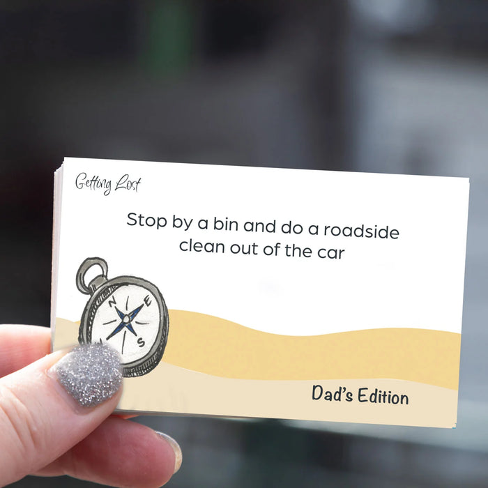 Card with humorous advice for car owners held by a hand