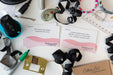 Desk with office supplies, ribbons, and decluttering cards on a white surface