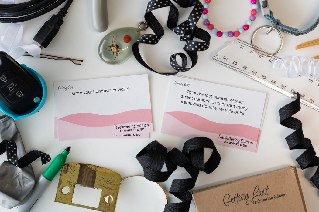Collection of items including ribbons, cards, and a box on a white surface