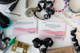 Desk with decluttering cards, ribbons, and office supplies on a white surface