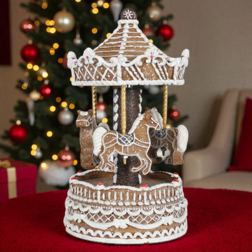 Gingerbread carousel with horses in front of a decorated Christmas tree.