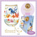 Decorative glass with floral and bird design, 24K gold cocktail carafe, and matching gift box on a light purple background.