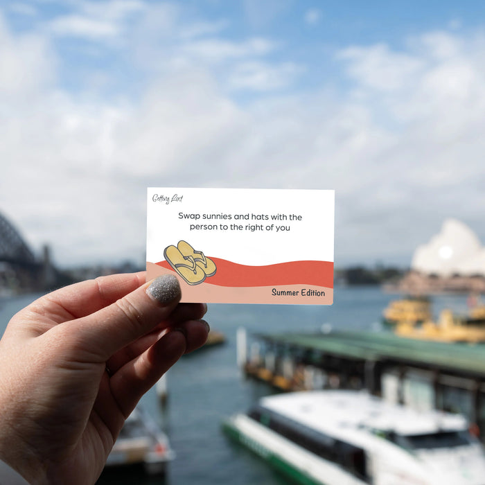 Hand holding a card with a scenic background of water and boats