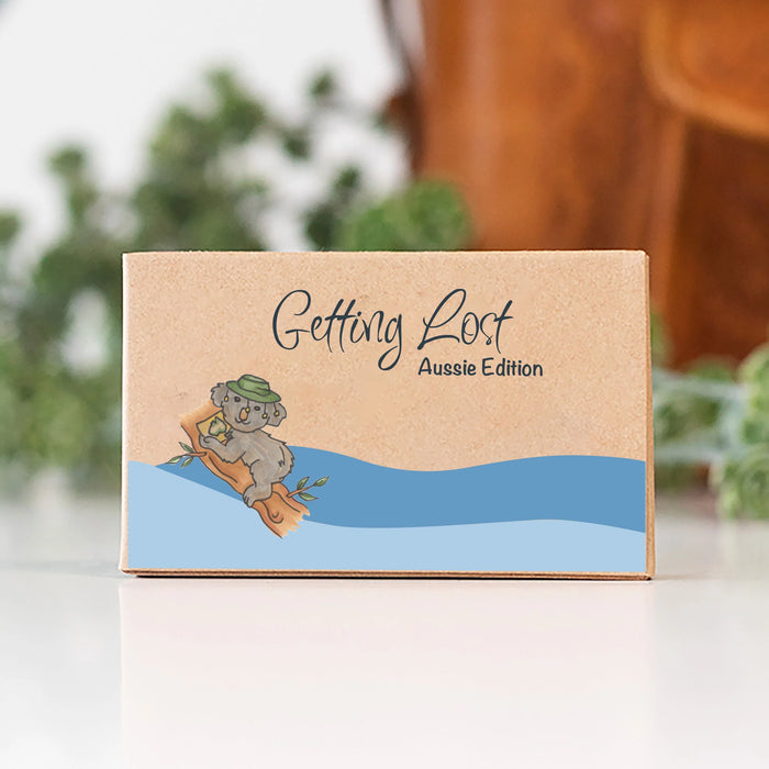 Cardboard box with a cartoon koala and 'Getting Lost Aussie Edition' text on a blurred natural background