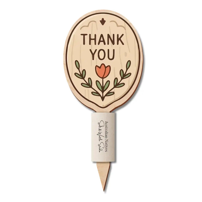 Natural wood-look oval Bloom Note reading “Thank You”, with a red flower, green leaves and Australian native seed paper sleeve.
