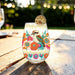 Brilliant Kookaburra stemless glass with a colorful kookaburra and floral design, shown with a lime cocktail garnish.