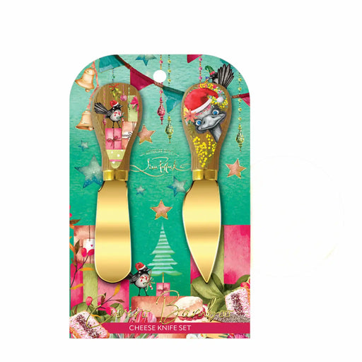 A cheese knife set in its original retail packaging, featuring two gold-colored cheese knives with whimsical, colorful cartoon handles on a festive green and pink backing card.