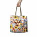 A tote bag with a colorful rustic western-themed print featuring a Highland cow, sunflowers, boots, and a cowboy riding a horse, held by a hand against a white background.