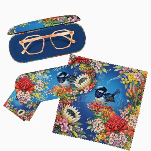 A set of eyewear accessories featuring a vibrant blue background with a multicolor floral and bird print. The set includes a hard protective case with rose gold-framed glasses resting inside, a matching lens cover, and a square microfiber cleaning cloth, all displayed on a clean white background.
