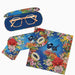 A set of eyewear accessories featuring a vibrant blue background with a multicolor floral and bird print. The set includes a hard protective case with rose gold-framed glasses resting inside, a matching lens cover, and a square microfiber cleaning cloth, all displayed on a clean white background.