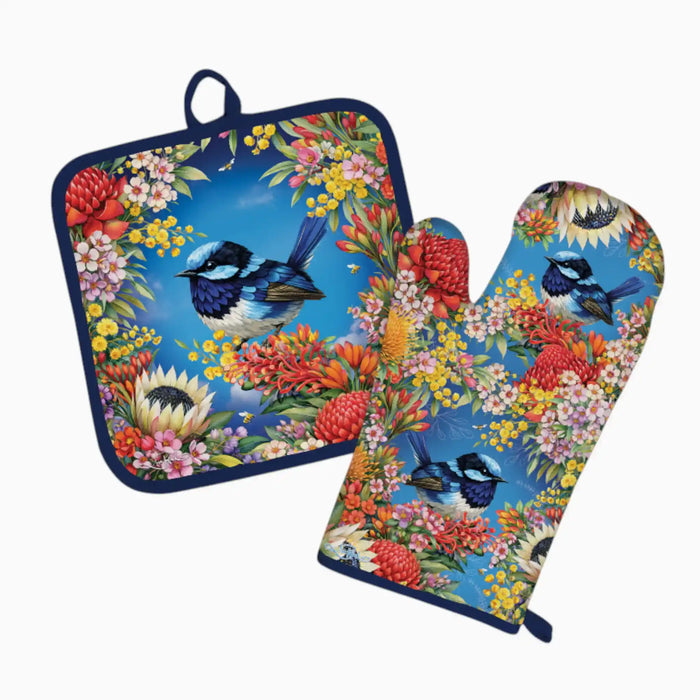 A matching kitchen set featuring a square pot holder and a large oven mitt, both printed with a vibrant tropical design of bluebirds, red protea flowers, and yellow flowers on a bright blue background.