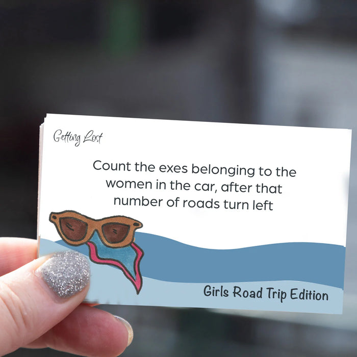 Card with humorous road trip instructions held by a hand