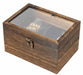 A rectangular wooden display case with a clear glass top lid and a small metal latch on the front, shown on a plain white background. Inside, a black leather item with gold text is partially visible through the glass.