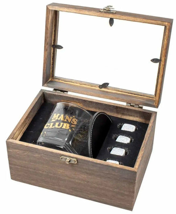 A wooden presentation box with a glass-look lid, shown open on a white background. Inside are a dark glass tumbler with gold lettering reading 'MANS CLUB', a black leatherette sleeve, and four small silver-toned rectangular pieces.