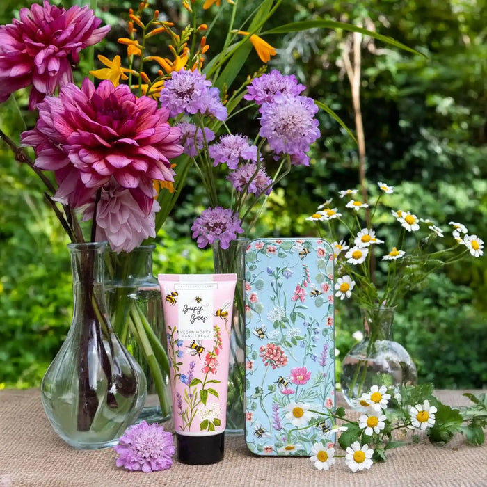 Floral-themed phone case and hand cream with flowers and greenery in the background