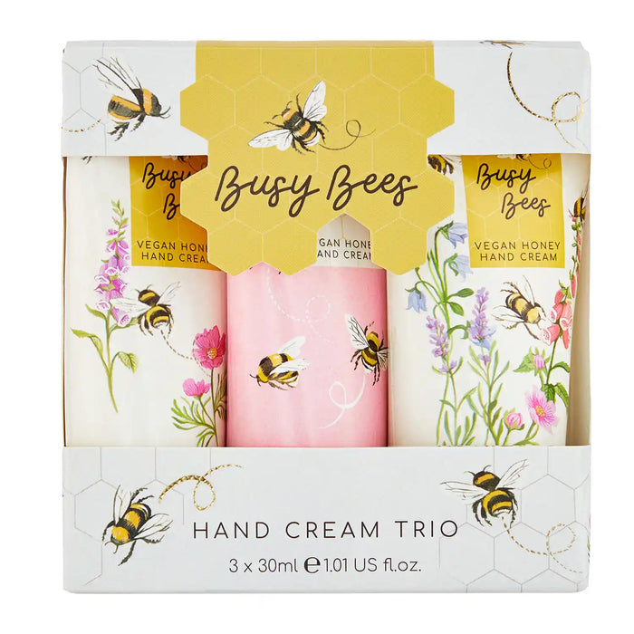 A boxed hand cream trio set labeled 'Busy Bees' with three cylindrical hand creams visible through a printed window box. The packaging is white and yellow with bee and floral illustrations, and the creams are decorated with bees and flowers.