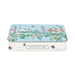 A rectangular metal tin with rounded corners, featuring a botanical illustration on the lid with pink flowers, green leaves, and bees over a light blue background. The front of the tin is white with a black label reading 'HEATHCOTE & IVORY'.