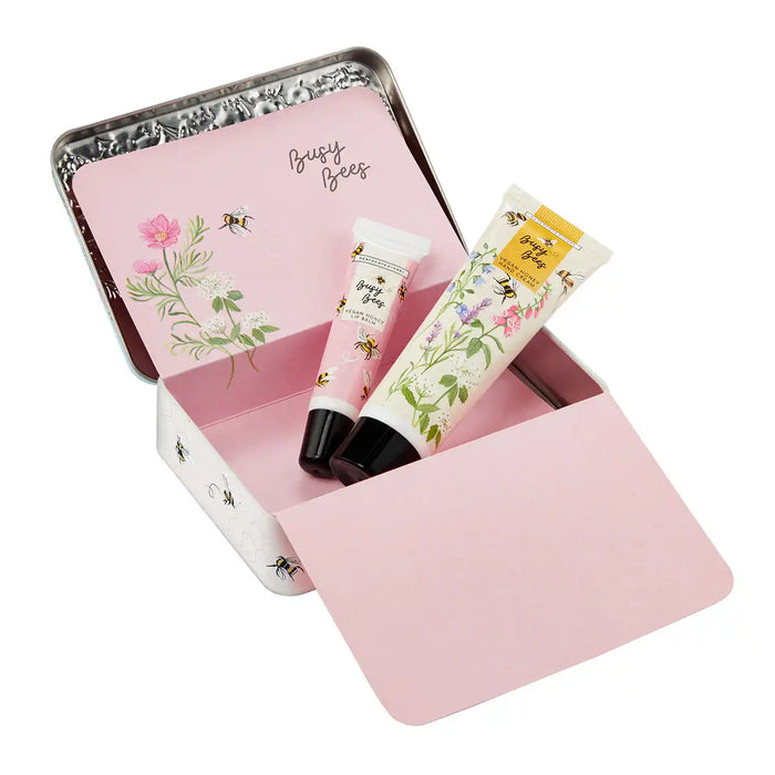 Pink tin with 'Busy Bees' branding containing two lip balms on a white background