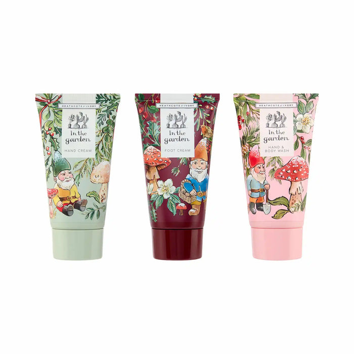 Three tubes of hand cream from The Little Bee 'In the Garden' line, shown side by side on a white background. The tubes feature whimsical garden gnome illustrations with different color palettes: sage green, deep burgundy, and light pink, decorated with leaves, mushrooms, and flowers.
