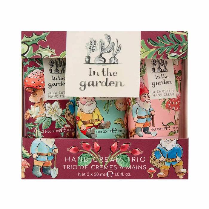 A boxed hand cream trio gift set labeled 'In the garden' with three decorated tubes visible inside a printed maroon box featuring gnomes, flowers, and mushrooms.