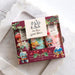 A boxed set of three hand creams in a decorative gift box labeled 'In the garden,' placed on a white marble tray over a light wood surface. The packaging features colorful garden-themed illustrations and text for hand cream trio.