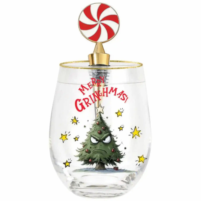 A clear stemless wine glass with a gold rim and a candy cane-shaped lid. The glass features a printed design of a grumpy Christmas tree with the text 'Merry Grinchmas!' in red, surrounded by yellow stars.