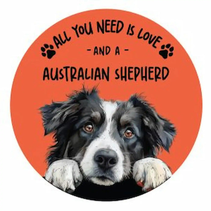 A circular coaster featuring a black and white Australian Shepherd dog peeking up against a bright orange background, with the text 'ALL YOU NEED IS LOVE - AND A AUSTRALIAN SHEPHERD' in black lettering and small paw prints.