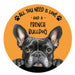 A circular coaster featuring a black French Bulldog on an orange background with the text 'ALL YOU NEED IS LOVE - AND A - FRENCH BULLDOG' and small black paw prints.