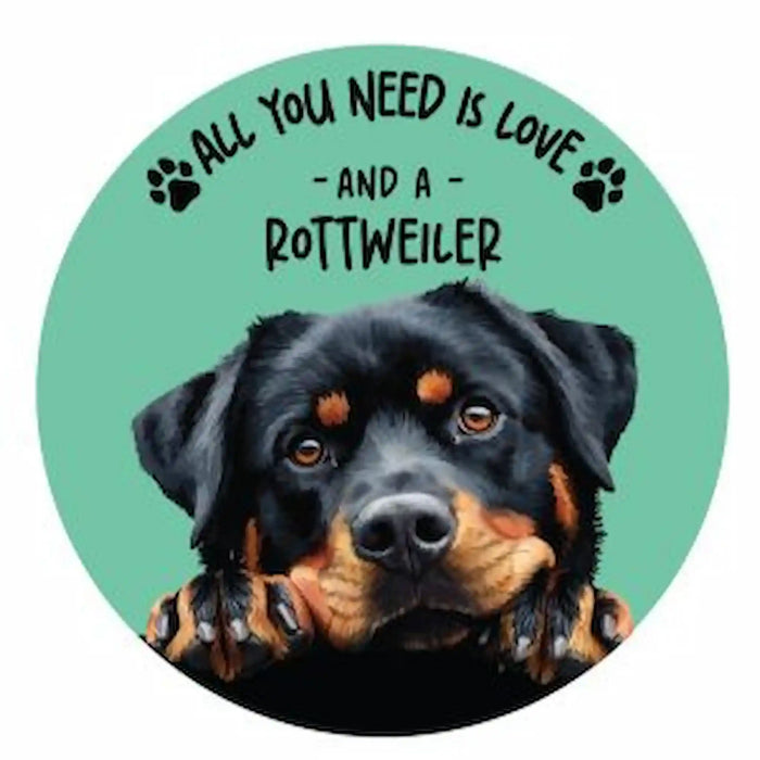 A circular coaster featuring a Rottweiler dog illustration on a mint green background with the text 'ALL YOU NEED IS LOVE - AND A ROTTWEILER' and paw prints.