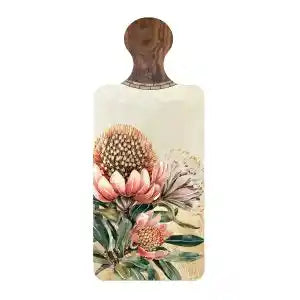 A rectangular wooden cutting board with a rounded handle, featuring a vintage botanical illustration of pink and cream protea flowers on a light background.