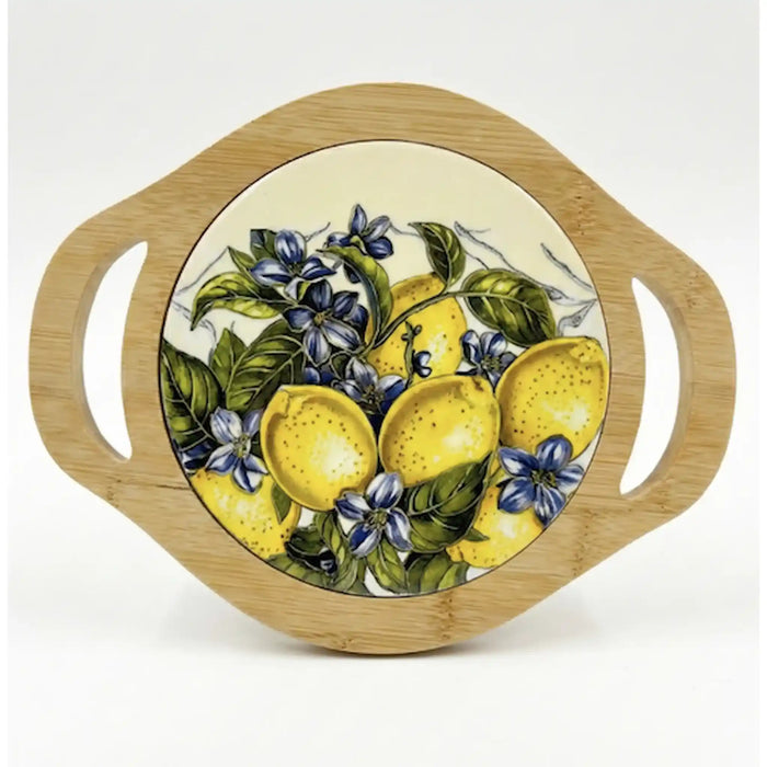 A round bamboo serving board with two side handles and a central printed illustration of lemons, green leaves, and blue flowers on a white background.