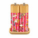 A pair of salt and pepper mills with light bamboo wood caps and bases, featuring vibrant pink striped bodies decorated with tropical and holiday illustrations, set against a plain white background.