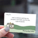 Hand holding a business card with camera illustration and text on a blurred background