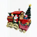 A festive Christmas train figurine with Santa Claus in the driver's seat, a red engine car, a red passenger car carrying a teddy bear, gifts, and a small decorated Christmas tree, shown on a plain white background.