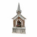 A miniature church-shaped nativity display with a white and gray facade, a gray shingled steeple, and a small interior figurine of the Holy Family visible through arched windows, set against a plain white background.