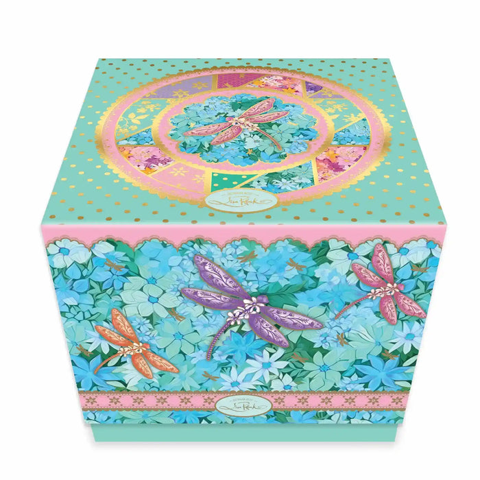 A square decorative gift box in mint green with gold polka dots, featuring colourful dragonfly illustrations in purple, pink, and orange over a background of blue and teal hydrangea florals. Photographed on a white background.