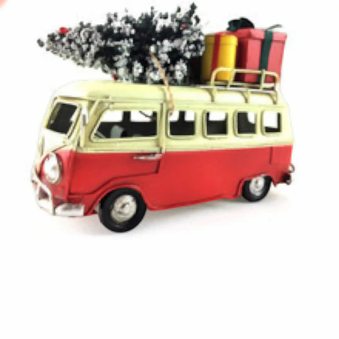 A vintage-style red and cream van ornament or toy with a roof rack carrying a Christmas tree and wrapped gifts, shown on a plain white background.