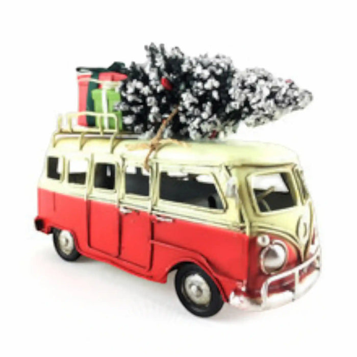 A vintage-style red and cream Volkswagen camper van ornament or toy, shown on a white background with a small flocked Christmas tree and wrapped gifts strapped to the roof.