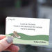 A hand with glittery nail polish holds a square card that reads 'Look at the time. Head in the direction the minute hand is pointing' with 'Getting Lost' at the top and 'Walkers Edition' at the bottom.