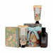 William Morris gift set featuring a floral and bird-patterned bath and body set, including a hand cream tube, lotion tube, boxed bath bomb, and a dark amber shower gel bottle, arranged on a white background.