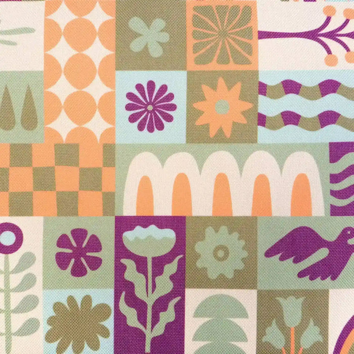 Close-up of the Bambury Zippora cooler bag fabric, showing a retro patchwork print of flowers, birds and geometric shapes in orange, magenta, olive, mint and cream on woven canvas